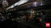 Warga menghabiskan waktu malam di depan rumah, di pinggir rel jalur kereta api Tanah Abang, Jakarta Pusat. Tim Gubernur untuk Percepatan Pembangunan (TGUPP) memastikan pemerintahan Anies Baswedan tidak akan melakukan penggusuran, namun lebih ke perencanaan penataan permukiman. CNNIndonesia/Adhi Wicaksono.