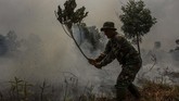 Personel TNI dari Kodim 0301 Pekanbaru juga membantu memadamkan api yang membakar semak belukar di lahan gambut. Selain dengan air, pemadaman juga dilakukan dengan cara sederhana yakni dengan ranting pohon. (ANTARA FOTO/Rony Muharrman)