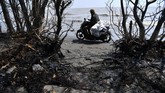 Warga membawa karung berisi ceceran minyak mentah yang berhasil dikumpulkan di Pantai Tanjungsari, Karawang, Jawa Barat, Kamis (8/8/2019). (ANTARA FOTO/Sigid Kurniawan/ama)