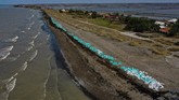 Tumpukan karung berisi ceceran minyak mentah di Pantai Mekarjaya, Karawang, Jawa Barat, Kamis (8/8/2019). (ANTARA FOTO/Sigid Kurniawan/ama)