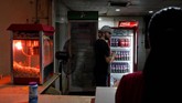 Seorang pembeli mengambil kaleng soda dari kulkas di suatu toko kecil di klub berkuda di Khartoum, Sudan. (REUTERS/Andreea Campeanu)