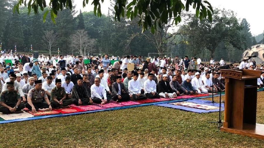 Jokowi menunaikan salat dengan mengenakan baju koko putih, peci hitam dan sarung berwarna gelap.