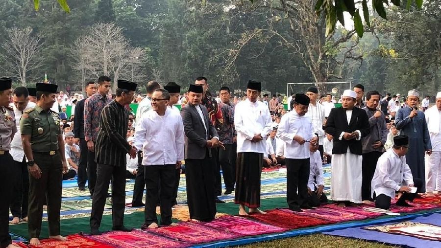 Jokowi menunaikan salat dengan mengenakan baju koko putih, peci hitam dan sarung berwarna gelap.