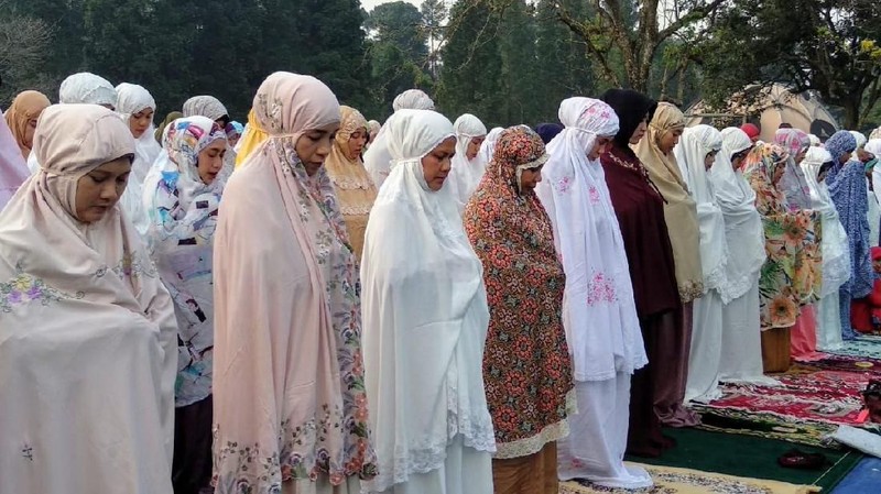 Jokowi menunaikan salat dengan mengenakan baju koko putih, peci hitam dan sarung berwarna gelap.