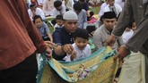 Dua remaja berkeliling sambil mengambil uang sedekah jamaah salat Idul Adha 1440 H di Lapangan Sepak Bola Sorumba, Kecamatan Ranomeeto, Konawe Selatan, Sulawesi Tenggara, Minggu (11/8/2019). (ANTARA FOTO/Jojon)