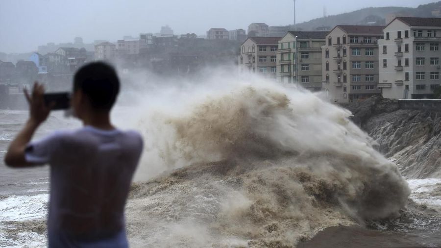 Topan Lekima memicu tanah longsor dan banjir setelah membuat pendaratan di Zhejiang Sabtu pagi, sekitar 300 kilometer (190 mil) selatan Shanghai.