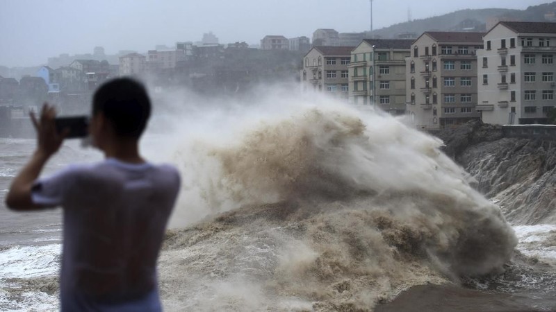 Topan Lekima memicu tanah longsor dan banjir setelah membuat pendaratan di Zhejiang Sabtu pagi, sekitar 300 kilometer (190 mil) selatan Shanghai.