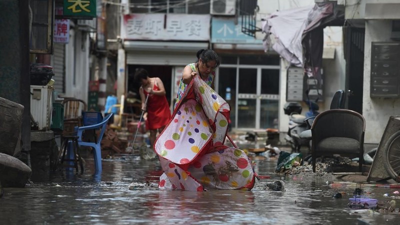 Topan Lekima memicu tanah longsor dan banjir setelah membuat pendaratan di Zhejiang Sabtu pagi, sekitar 300 kilometer (190 mil) selatan Shanghai.