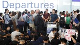 Ribuan pengunjuk rasa pro-demokrasi memenuhi kawasan bandara Hong Kong sambil memegang papan bertuliskan