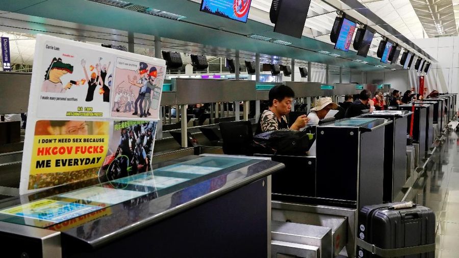 ATTENTION EDITORS - SENSITIVE MATERIAL. THIS IMAGE MAY OFFEND OR DISTURB Passengers rest at check in counter during a mass demonstration after all flights are cancelled at Hong Kong International Airport, China August 12, 2019. REUTERS/Tyrone Siu