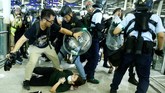 Anggota pasukan anti huru-hara mulanya sempat terlibat aksi saling dorong dengan massa. Mereka lantas menyemprotkan semprotan merica hingga membuat demonstran kocar-kacir menyelamatkan diri. (REUTERS/Thomas Peter)