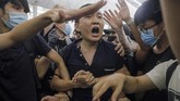 Massa demonstran yang menduduki bandara Hong Kong sempat menangkap dan menganiaya seorang lelaki yang memegang paspor China. Setelah ditelusuri, ternyata dia bernama Fu Guohao yang merupakan reporter surat kabar Global Times. (AP Photo/Vincent Yu)