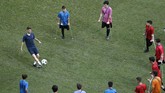 Gelandang Chelsea Jorginho mengumpan bola ke fan difabel di sela sesi latihan di Stadion Besiktas Park Stadium. (AP Photo/Lefteris Pitarakis)