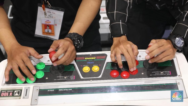 Dari Ding dong sampai PS1 Warga Nostalgia Main Game Era 90an Warga bermain game console clasic di pameran pasar idea 2019, JCC, Jakarta, Kamis (15/8). Game game console seperti sega Nintendo dan ding dong dulu sempat tenar di era 90an sebelum game online yang bermunculan saat ini. KomunitasRepublic Games Collector Indonesia (RGCI) itu awalnya dibentuk oleh beberapa teman saja. Kebetulan sama-sama seneng main dan koleksi konsol game. Berdiri tahun 2016 ini kini sedikitnya memiliki 2.600 orang pengikut di Facebook, yang tersebar di seluruh wilayah. Bukan sekedar mengoleksi, di komunitas ini kita juga bisa saling berbagi wawasan tentang game yang ada di dunia ini. Pengunjung pameran setelah melihat-lihat stan pameran juga dapat bermain dan bernostalgia dengan game game terkenal seperti sonic mario bross sampai CTR. Stand game retro ini dipajang sengaja untuk menarik perhatian pengunjung dan tidak dijual. (CNBC Indonesia/Muhammad Sabki)