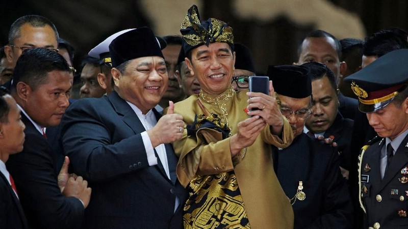 Pakaian adat Sasak yang dikenakan Jokowi berwarna keemasan lengkap dengan tutup kepala dan keris.