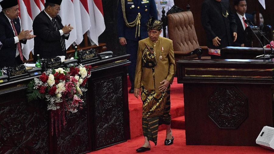 Pakaian adat Sasak yang dikenakan Jokowi berwarna keemasan lengkap dengan tutup kepala dan keris.