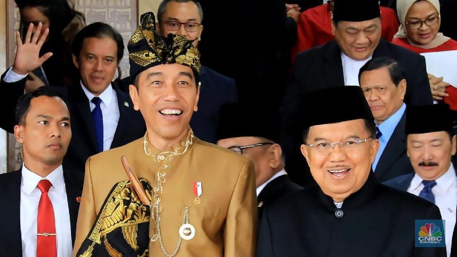 Pakaian adat Sasak yang dikenakan Jokowi berwarna keemasan lengkap dengan tutup kepala dan keris.
