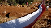 Sejumlah warga membentangkan bendera merah putih di atas Bukit Tokka, Desa Bontomarannu, Kabupaten Maros, Sulawesi Selatan, Sabtu (17/8). Pembentangan bendera merah putih berukuran 400 meter tersebut dalam rangka memperingati HUT ke-74 Kemerdekaan RI. (ANTARA FOTO/Abriawan Abhe/foc)