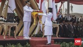 Gubernur DKI Jakarta Anies Baswedan memberikan bendera merah putih kepada Paskibraka saat upacara peringatan Hari Ulang Tahun ke-74 Republik Indonesia di Pantai Maju, Pulau D Reklamasi, Jakarta. (CNN Indonesia/Bisma Septalisma)