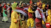 Sejumlah peserta berpakaian daerah membawa panji-panji saat mengikuti Parade Kirab Bendera Merah Putih dari Monas menuju Istana Merdeka di Jakarta. (CNN Indonesia/ Adhi Wicaksono)