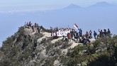 Pendaki mengibarkan bendera Merah Putih sambil menyanyian lagu kebangsaan Indonesia Raya saat memperingati Hari Ulang Tahun ke-74 Proklamasi Kemerdekaan RI di kawasan Puncak Gunung Lawu Magetan, Jawa Timur, Sabtu (17/8). (ANTARA FOTO/Siswowidodo)