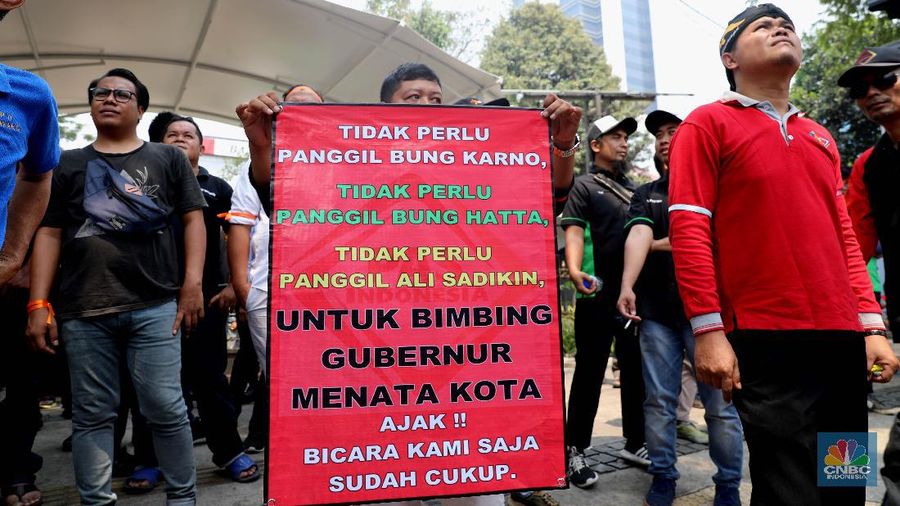 Karena perluasan wilayah ganjil-genap, para pengemudi taksi online berdemo di Balai Kota Jakarta.
