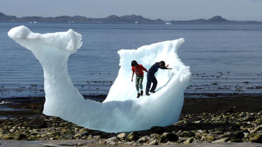 FILE PHOTO: Children play amid icebergs on the beach in Nuuk, Greenland, June 5, 2016. REUTERS/Alister Doyle/File Photo