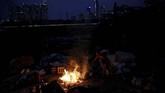 Seorang pria membakar sampah di area kumuh di Jakarta. (REUTERS/Willy Kurniawan)