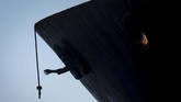Seorang kru berupaya menggapai tali di tanker super 'Grace 1' yang kini menjadi 'Adrian Darya 1'. (AP Photo/Marcos Moreno)