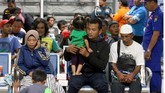 Sejumlah korban kapal terbakar KM Santika Nusantara beristirahat di Gapura Surya Nusantara, Pelabuhan Tanjung Perak, Surabaya, Jawa Timur, Jumat (23/8/2019) malam. Sekitar 64 orang penumpang KM Santika Nusantara dievakuasi ke kapal KM Dharma Ferry VII yang sedang melintas. ANTARA FOTO/Didik Suhartono