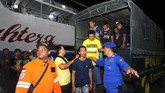 Petugas mengarahkan penumpang kapal terbakar KM Santika Nusantara masuk ke Gapura Surya Nusantara, Pelabuhan Tanjung Perak, Surabaya, Jawa Timur, Jumat (23/8) malam. Data penumpang yang dievakuasi dari KM Santika lebih banyak dibandingkan jumlah manifes penumpang. ANTARA FOTO/Didik Suhartono