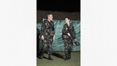 Sineenat juga terlihat tengah menggendong dua ransel besar, sementara sang suami menggendong seekor poodle yang merupakan anjing kerajaan. (Royal Household Bureau/Handout via REUTERS)