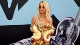 Tana Mongeau mungkin terinspirasi dari Britney Spears dengan baju seksi dan membawa ular berwarna senada dengan busananya. (Dia Dipasupil/Getty Images for MTV/AFP)