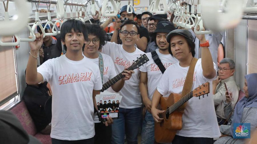 Aksi Band D'Masiv saat menghibur penumpang di dalam Kereta Rel Listrik di Jakarta, Senin (2/9/2019).  Band D'Masiv menghibur penumpang KRL dalam rangka merayakan Hari Pelanggan Nasional yang jatuh tiap tanggal 4 September. Grup band yang digawangi Rian ini menghibur pengguna jasa KRL dengan menyanyikan sejumlah lagu hits mereka. di Dalam KRL. Rian juga mengajakpara pengguna jasa untuk mencintai KRL Commuter Line dengan menjaga ketertiban dan kenyamanan bersama di kreta. (CNBC Indonesia/Muhammad Sabki)