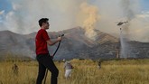 Caden Terry, 15, berupaya sekuat tenaga bersama para tetangganya untuk memadamkan api di Toole, Utah, AS. (Francisco Kjolseth/The Salt Lake Tribune via AP)