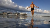 Seorang pegiat kebugaran Johnny C, 63, melakukan lompat tali di pantai Old Orchard Beach, Maine, Amerika Serikat. (AP/Robert F. Bukaty)