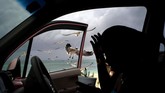 Burung camar terbang ke arah seorang perempuan yang memberikan mereka makanan kentang goreng dari mobilnya, di Pantai Taino, Bahama, sebelum badai Dorian menerjang daerah itu. (AP/Ramon Espinosa)