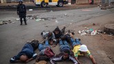 Warga yang ditangkap di kota kecil Johannesburg, Katlehong, berbaring di tanah pada Kamis (5/9). (Photo by Michele Spatari / AFP)