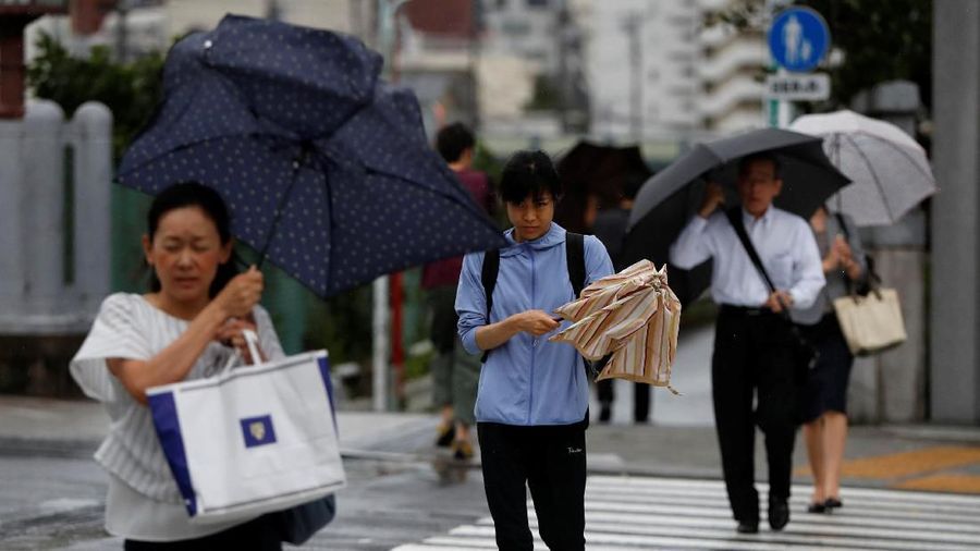 Passersby using umbrellas struggle against heavy rain and wind wind caused by Typhoon Faxai in Tokyo, Japan September 9, 2019.  REUTERS/Issei Kato