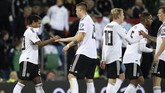 Serge Gnabry mendapatkan selamat dari rekan-rekan setimnya setelah mencetak gol kedua Jerman ke gawang Estonia. Kemenangan ini membuat Jerman kukuh di puncak klasemen. (AP Photo/Peter Morrison)