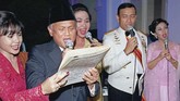 Pada HUT RI ke-54 pada 17 Agustus 1999, BJ Habibie bernyanyi bersama Wiranto dan beberapa penyanyi perempuan di Istana Merdeka. (Photo by AGUS LOLONG / AFP)