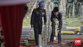 Presiden Joko Widodo (kanan) selaku Inspektur Upacara meletakkan karangan bunga di makam BJ Habibie. (CNN Indonesia/Adhi Wicaksono)