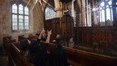 Guest Ismail Abdirahman (top) reads to his friends Andrea Stewart, Lingbo Zhou and Kae Ono from the pulpit at St Mary's Church, where guests can pay to stay overnight in what is known as 'champing', in Edlesborough, Buckinghamshire on September 2, 2019. (GLYN KIRK / AFP)