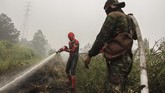 Seorang warga mengenakan kostum superhero membantu petugas BPBD Riau dan TNI Kodim 0313 Kampar saat memadamkan kebakaran lahan gambut di Rimbo Panjang, Kabupaten Kampar, Riau, Kamis (12/9/2019). Singapura dan Malaysia juga telah menawarkan bantuan untuk memadamkan karhutla. (ANTARA FOTO/Rony Muharrman)