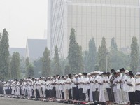 Arms clasped, Muslims pray for rain in Pekanbaru, Riau province, Indonesia, Wednesday, Sept. 11, 2019. Authorities shut most schools in parts of Indonesia's Sumatra island to protect children from a thick, noxious haze as deliberately set fires burne