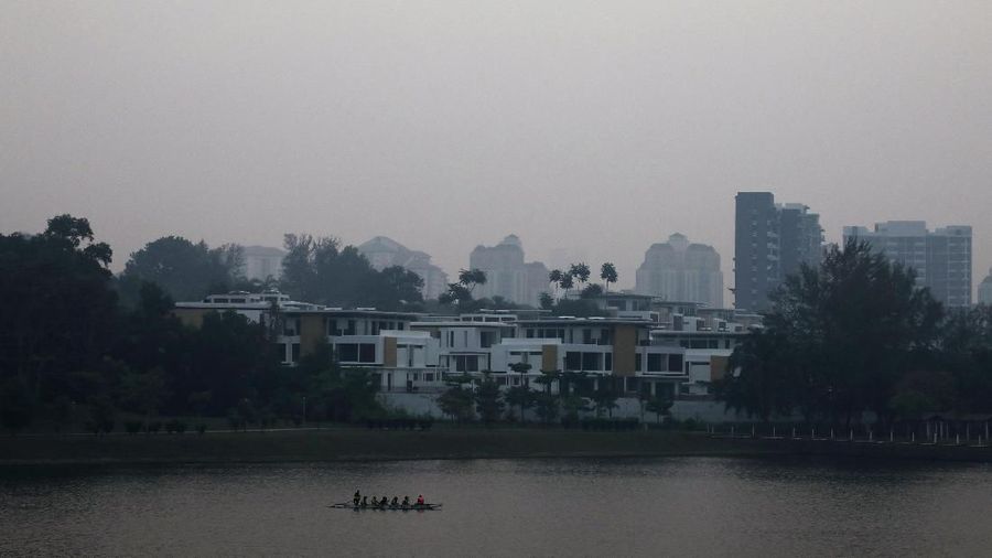 A boat passes by a residential area shrouded in haze in Putrajaya, Malaysia, September 17, 2019. REUTERS/Lim Huey Teng