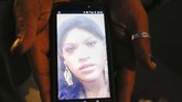 Kenya memperlihatkan foto temannya sesama transgender yang tewas dibunuh, Paola Buenrostro. Dia diberondong tembakan oleh seseorang yang berpura-pura menyewa jasa seks komersial. (AP Photo/Ginnette Riquelme)
