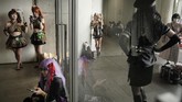 Peminat cosplay (kostum) melihat ponsel pintar mereka di koridor, saat beristirahat di sela acara Tokyo Game Show di China, dekat Tokyo, Jepang. (AP/Jae C. Hong)