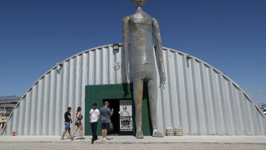 People enter and exit the Alien Research Center in Hiko, Nev. No one knows what to expect, but lots of people are preparing for