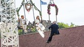 Dari kiri ke kanan, pengantin Sven Lier dan Anna Traber dan Wali Kota Breisach, Oliver Rein, dalam upacara pernikahan sambil 'melayang' di udara di Breisach, Jerman. (Philipp von Ditfurth/dpa via AP)